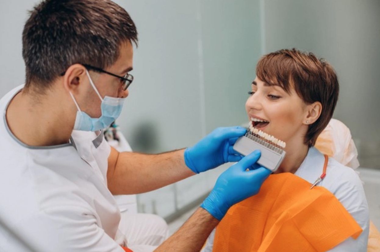 Dentist matching denture shade with a patient using a tooth shade guide
